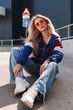 Leinwandbild Motiv modern retro style 90s, girl in a blue sports jacket, cassette player, listening to music, urban style mood