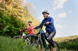 © Halfpoint - Low angle view of happy active senior women friends cycling together outdoors in nature.