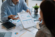 © Natee Meepian - Business team meeting present, investor colleagues discussing new plan financial graph data on office table with laptop and digital tablet, Finance, accounting, investment.