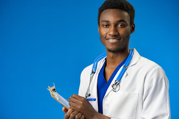 Wall Mural - Confident black doctor posing over blue studio background.