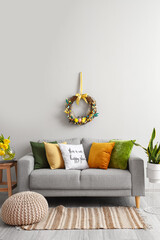 Wall Mural - Comfortable sofa near light wall with Easter wreath in living room