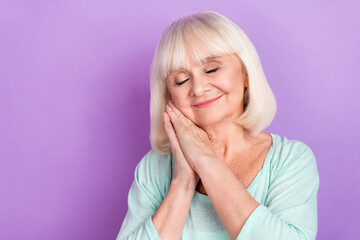 Sticker - Photo of relaxed dreamy cute grandma hands cheek enjoy sleep close eyes wear blue shirt isolated violet color background