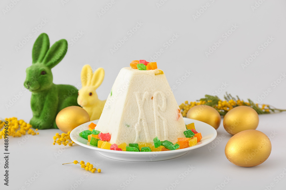 Traditional curd Easter cake with candied fruits and golden eggs on light background