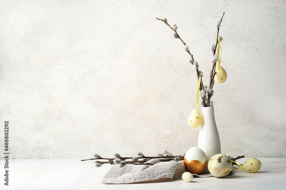 Composition with painted Easter eggs and pussy willow branches on light background