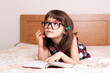 © gmstockstudio - Little girl reading a book at home