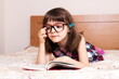 © gmstockstudio - Little girl reading a book at home
