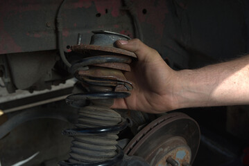 Wall Mural - Rusty car shock absorber with crushed metal at the base