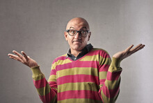Portrait Of Bald Man While Making Gesture Of Not Knowing The Answer