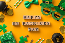 Top View Photo Of Wooden Cubes Labeled Happy St Patricks Day Hat Shaped Party Glasses Straws Green Bow-tie Giftbox Shamrocks Pots And Gold Coins On Isolated Yellow Background