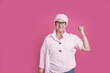 © ADDICTIVE STOCK - Cheerful sick woman showing bicep for positive attitude