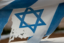 Closeup Of The Blue Star Of David On A Dirty, Torn And Shredded Flag Of The State Of Israel.