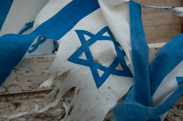 Wall Mural - Closeup of the blue Star of David on a dirty, torn and shredded flag of the State of Israel.