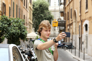 Wall Mural - Teenage boy typing text message,Using smart phone,young man on a city street