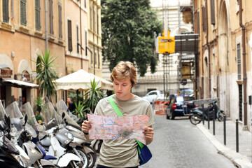 Wall Mural - Using smart phone.Teenage boy typing text message.Tourist looking at map