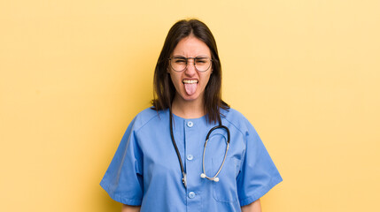 young hispanic woman with cheerful and rebellious attitude, joking and sticking tongue out. nurse concept