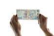 Woman checking Turkish lira banknote against light. Fake money concept.