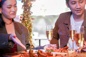 Wall Mural - Party of beautiful asian friend female and male celebrating. woman preparing food on table with snack and drink. happiness friends christmas eve celebration dinner party food and champagne.