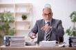 © Elnur - Old male employee and too much work in the office