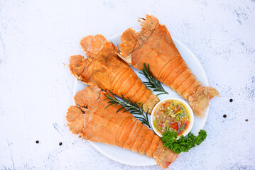 Wall Mural - Fresh slipper lobster flathead boiled cooking with parsley rosemary in the seafood restaurant, Flathead lobster shrimps served on white plate and seafood sauce, Rock Lobster Moreton Bay Bug