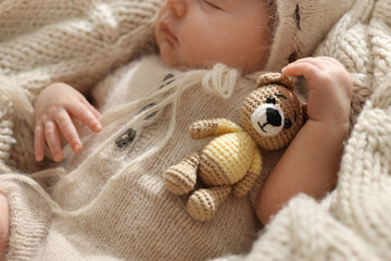 Wall Mural - Adorable newborn baby with toy bear sleeping on knitted plaid