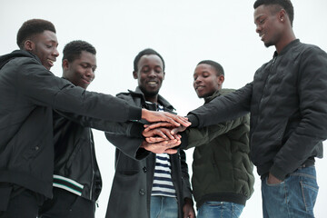 Wall Mural - close up. group of guys putting their hands together.