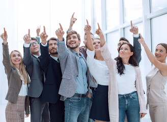 Wall Mural - group of happy young business people pointing upwards