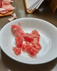 Sticker - Red pomelo slices lie on plate ready for cooking