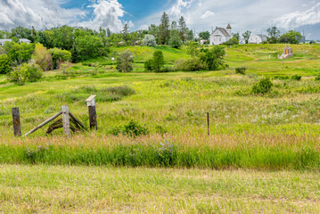 View of Trossachs United Church from behind with a meadow in the foreground in the ghost town of Trossachs, SK