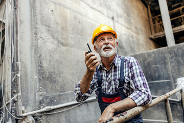 Wall Mural - An old factory worker with communicates with coworkers over the walkie-talkie.