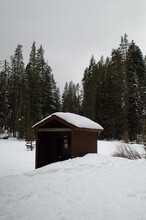 Public Restroom Log Cabin In Snow Surrounded By Pine Tree Field Yosemite National Park