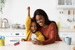© Prostock-studio - Happy Excited Black Mother And Little Daughter Celebrating Success With Smartphone