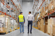 © Syda Productions - wholesale, logistic business and people concept - manual worker and businessman walking along warehouse