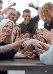 close up. handshake of young people to the applause of their friends.