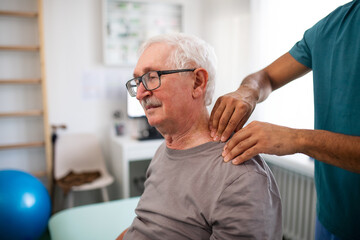Wall Mural - young physiotherapist massaging the neck of senior patient in a physic room