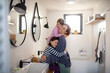 © Halfpoint - Mother hugging her little children in bathroom at home.