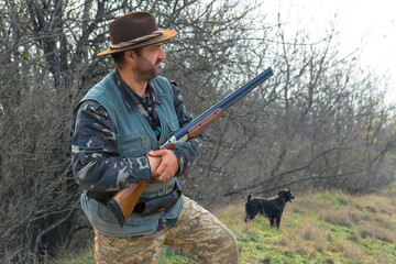 Wall Mural - Hunter man in camouflage with a gun during the hunt in search of wild birds or game. Autumn hunting season.