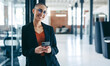 © Jacob Lund - Confident businesswoman smiling while holding a smartphone