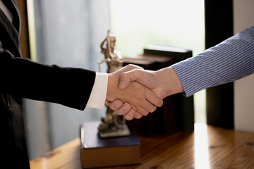 Lawyers shake hands with clients who come to testify in the case of embezzlement from business partners who jointly invest in the business. The concept of hiring a lawyer for legal proceedings.