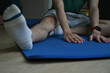 © saltdium - A cropped view portrait of a young man stretching his leg and touching on a mat in a living room, for home exercise, yoga and a class concept.