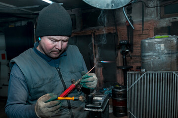 Canvas Print - Welder solders copper car radiator with gas torch