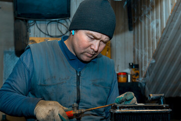 Canvas Print - Welder solders copper car radiator with gas torch