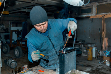 Wall Mural - Welder cleans a copper car radiator with a metal brush and a torch