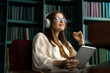 © muse studio - Tablet audiobook woman wireless headphones, office workplace report place. A student with glasses in the library.