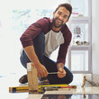 © Yuri Arcurs/peopleimages.com - Decorating one tile at a time. Portrait of a smiling man laying floor tiles.