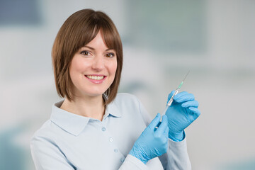 Wall Mural - smiling female doctor or nurse with syringe pulled up with a vaccination serum