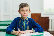 Portrait Of A Boy In A Blue Embroidered Traditional Ukrainian Shirt, Boy Holding A Pen In His Hand.