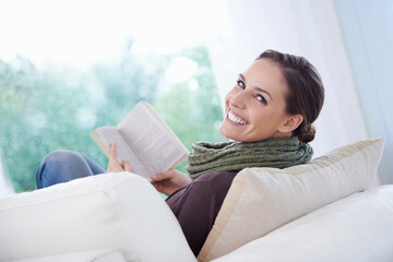 Poster - This novel is so engrossing. A relaxed young woman reading an engrossing novel on her couch.