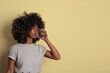 © face_reader_img - Young woman drinking mineral water for body refreshment on yellow background.
