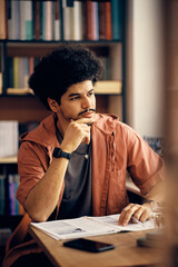 Wall Mural - Pensive Middle Eastern college student learns in library.