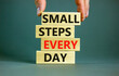 © Dzmitry - Small steps every day symbol. Concept words Small steps every day on wooden blocks. Businessman hand. Beautiful grey table grey background. Small steps every day business concept. Copy space.